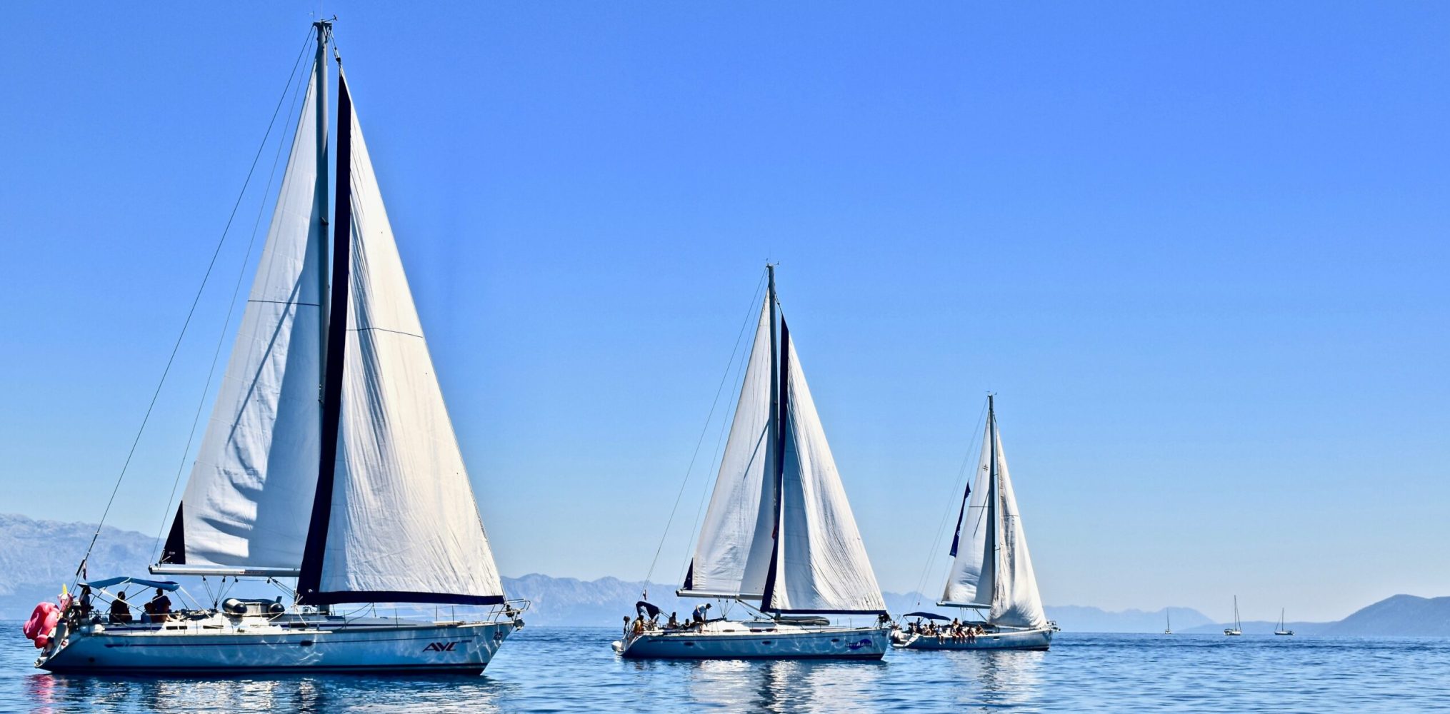 Three yachts sailing across the sea